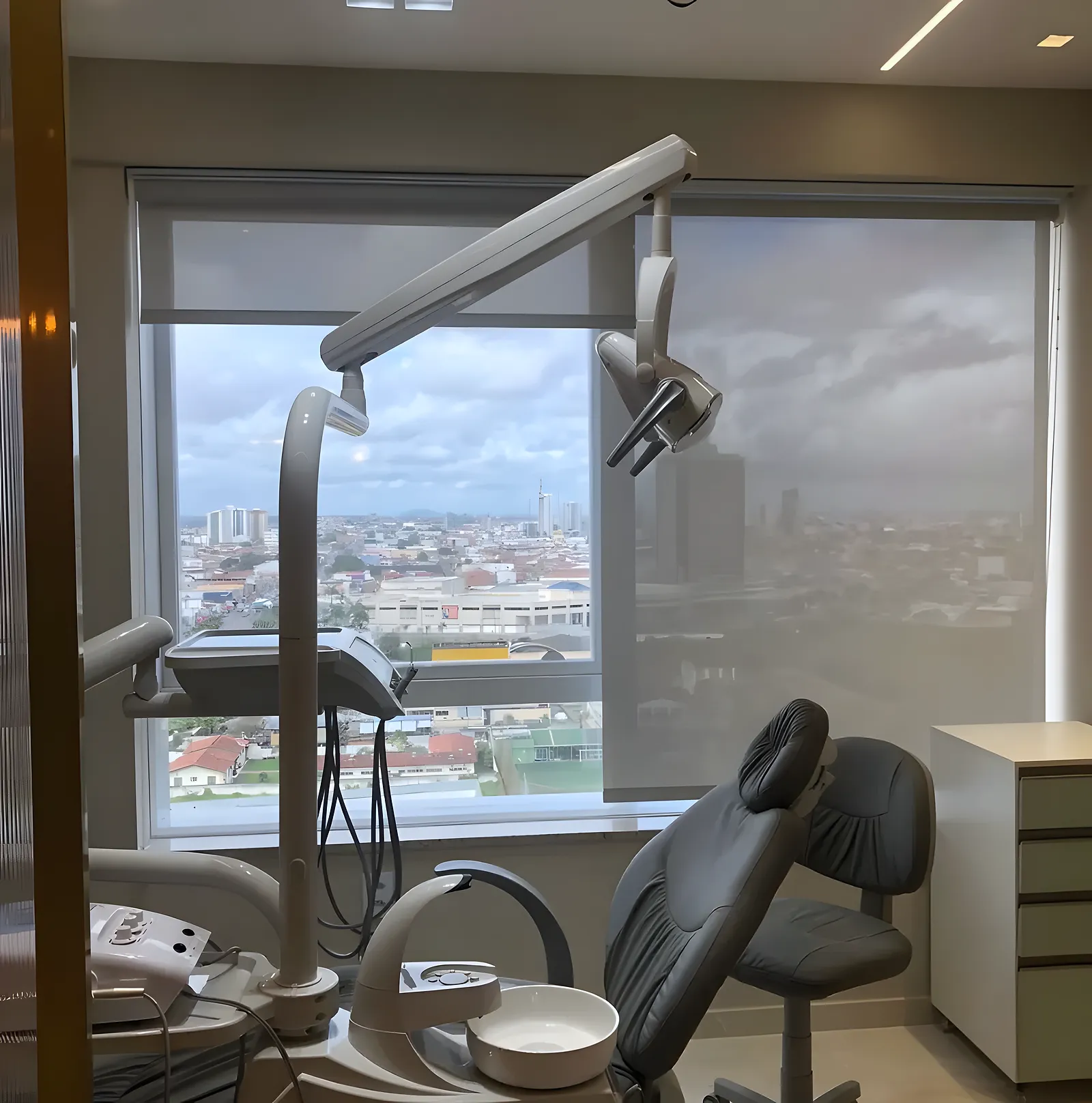 Persiana rolô tela solar em consultório odontológico, filtrando a luz sem esconder a vista da cidade, em Feira de Santana